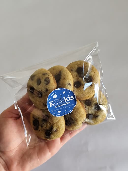 Bolsita transparente sellada con seis galletas con chips de chocolate y el sticker azul de Kookis.